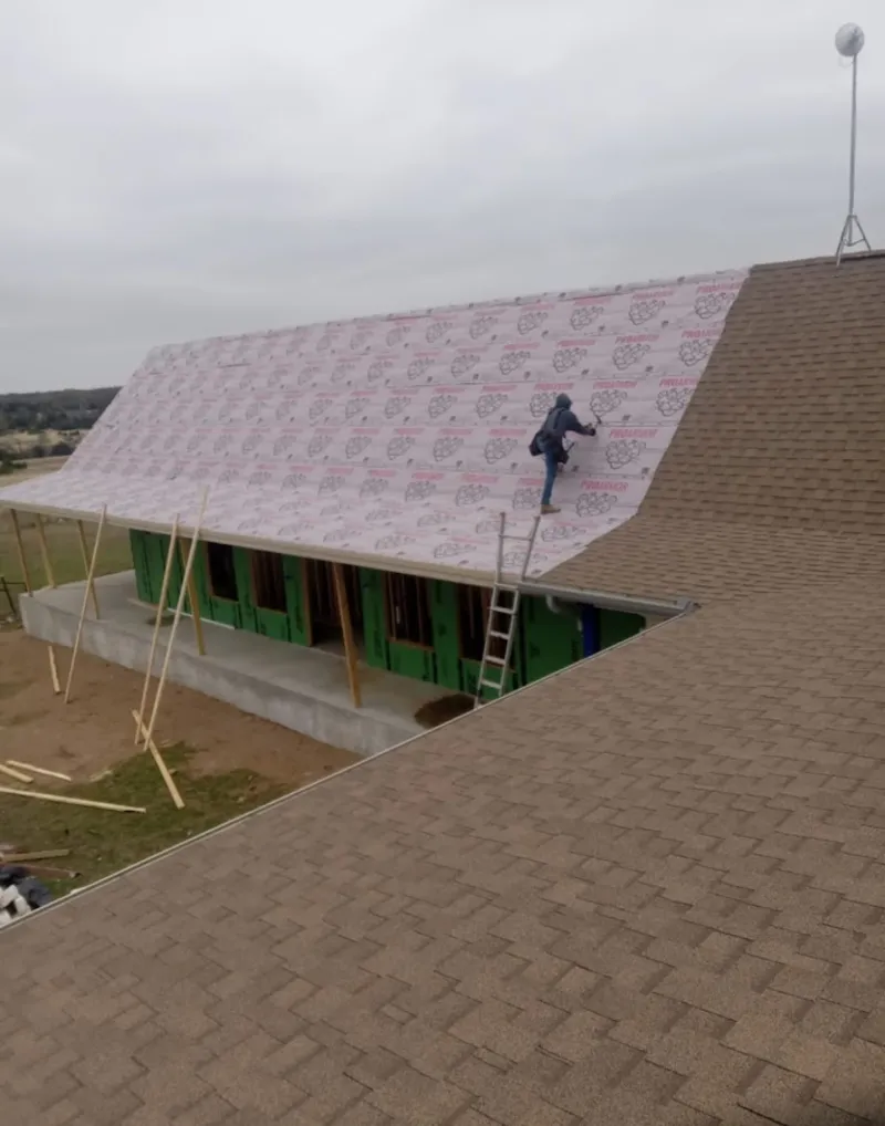 Worker preparing underlayment for a metal roof installation in Mount Hood Villages